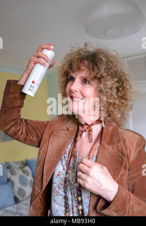 Reife Frau mittleren Alters mit Haarspray auf die markierten blondes lockiges Haar bereit für Asche Abend Foto aufgenommen von Simon Dack Stockfoto