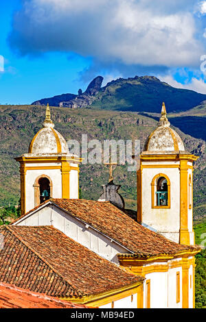 Blick auf eine von mehreren Kirchen und ihrem Glockenturm in Barock und koloniale Architektur der Stadt Ouro Preto in Minas Gerais mit seinen Bergen Stockfoto