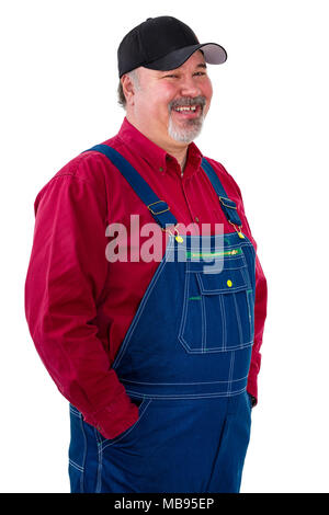 Lächelnd entspannte Arbeiter oder Bauer in Overalls stehen mit den Händen in den Taschen zur Seite gedreht mit einem Blick der Amusement isoliert auf weißem Stockfoto