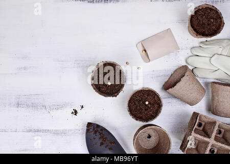 Gartengeräte, Samen und Erde auf eine weiße Holztisch. Bild geschossen von oben im flachen Stil legen. Stockfoto