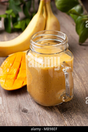 Mango Bananen Smoothie in Mason jar auf alten hölzernen Hintergrund Stockfoto