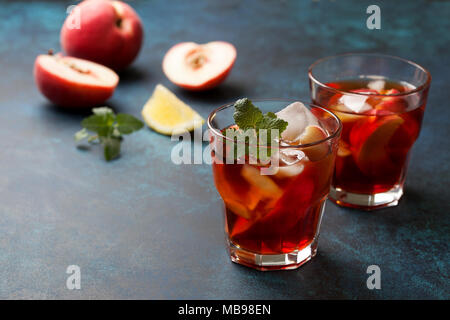 Kalter Tee Pfirsich mit Eis in Gläsern auf einem blauen Hintergrund Stockfoto