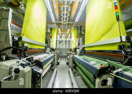 Maschinen und Anlagen in der Weberei. Innenraum der industriellen Textilfabrik. Webstuhl Stockfoto