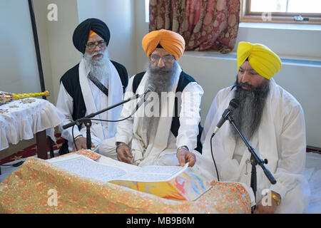 Sikh Priester, Granthis, lesen Sri Guru Granth Sahib, dem heiligen Buch der Sikhs. In Richmond Hill in Queens, New York. Stockfoto