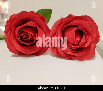 Fake rote rose Blumenstrauß auf dem Tisch weißer Hintergrund, rose Stoff Textur, künstliche rose flower bouquet. Stockfoto