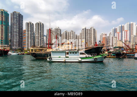 Hohe Gebäude bieten die Kulisse für Fischerboote im Hafen Aberdeen, Hong Kong. Stockfoto