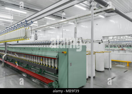 Maschinen und Anlagen in der Werkstatt zur Herstellung von Fäden, allgemeine Ansicht. Innenraum der industriellen Textilfabrik Stockfoto