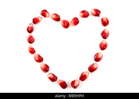 Frischen, rohen Samen der Granatapfel Obst mit Herz Symbol auf weißem Hintergrund, Herz Symbol aus Samen der Granatapfel Obst auf weißem backgr Stockfoto