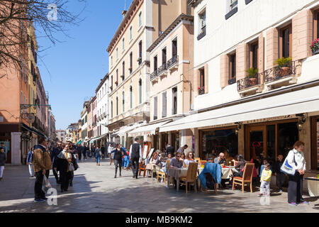 Viel befahrenen Straße Szene auf Strada Nova, Cannaregio, Venedig, Venetien, Italien mit Menschen essen in Restaurants und Einkaufsmöglichkeiten in den Geschäften und Kaufhäusern in der Feder Stockfoto