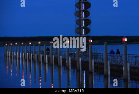 Bitterfeld Wolfen, Deutschland. 26 Juni, 2016. Touristen machen sich auf den Weg entlang der Mole bis zum Turm am Goitzsche See am Abend des 26.06.2016 in der Nähe von Bitterfeld, Deutschland. | Quelle: dpa/Alamy leben Nachrichten Stockfoto