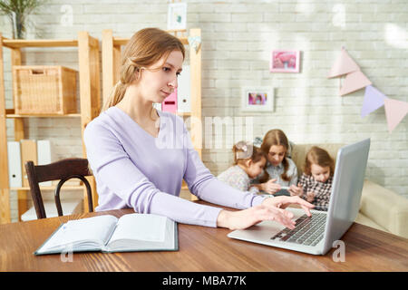 Junge Mutter eingehüllt in Arbeit Stockfoto