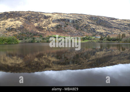 Die Hügel rund um den See bei Gougane Barra, Irland in den noch dunklen Wasser des Sees spiegelt. Ein beliebtes Ziel für Touristen und Urlauber. Stockfoto