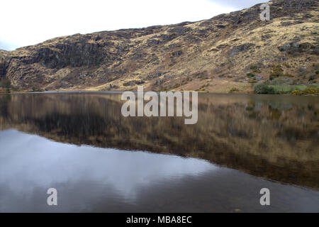 Die Hügel rund um den See bei Gougane Barra, Irland in den noch dunklen Wasser des Sees spiegelt. Ein beliebtes Ziel für Touristen und Urlauber. Stockfoto