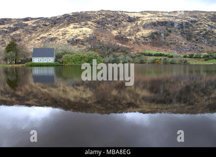 Gougane Barra Kirche und Schrein des Heiligen Finbarr, dem ersten Bischof von Cork, in der stimmungsvollen See Umgebung der Kirche wider. Stockfoto