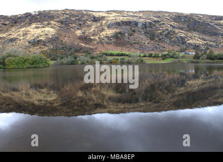 Die Hügel rund um den See bei Gougane Barra, Irland in den noch dunklen Wasser des Sees spiegelt. Ein beliebtes Ziel für Touristen und Urlauber. Stockfoto