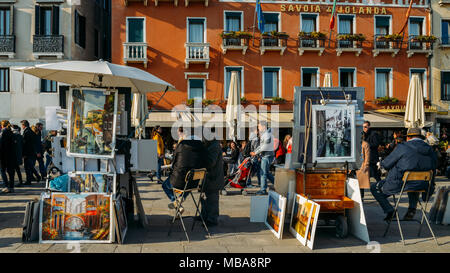 Unbekannter Künstler verkauft Gemälde auf der Uferpromenade in Venedig. Touristen aus aller Welt die historische Stadt von Venedig in Italien genießen, berühmten UNESCO-Welterbe Stockfoto