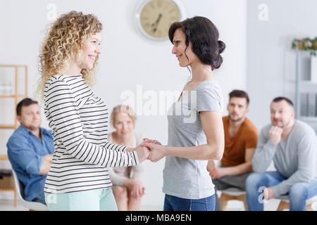Glückliche Mutter und Tochter stehen und Hände halten in der Familie Beratung in einer hellen Psychologe Stockfoto