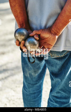 Mann spielt Petanque in einem französischen Dorf Stockfoto