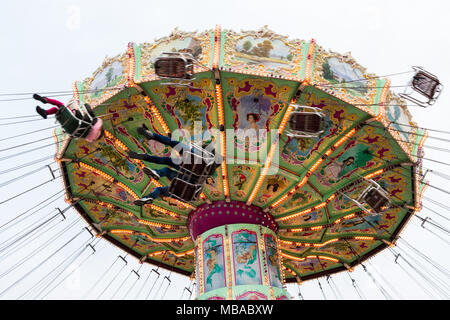 Low Angle View der beweglichen luftikus auf Karussell oder Kette swing Fahrt am bewölkten Tag, Prater. Stockfoto