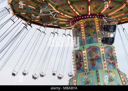 Seitenansicht des bewegten Luftikus auf Karussell oder Kette swing Fahrt am bewölkten Tag, Prater. Stockfoto