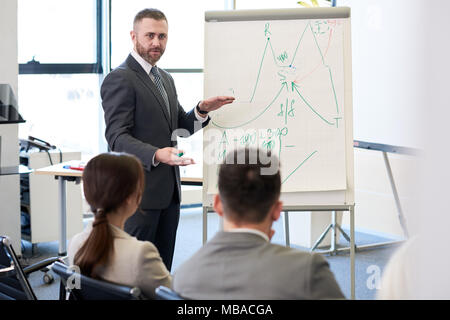 Ausgereifte Trainer am Whiteboard Stockfoto