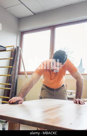 Tischler polieren und Lackieren einer Tabelle Stockfoto