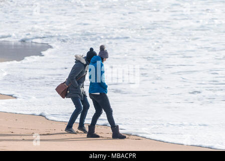 Frauen beobachten die Flut auf den Fistral Beach in Newquay Cornwall. Stockfoto