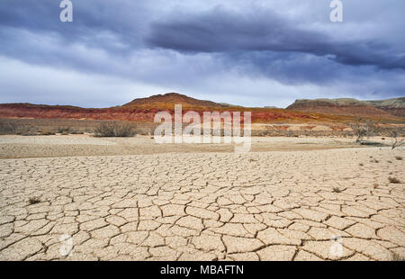 Trockene rissige Boden im Desert Park und regnerischen Wolken über die Berge Stockfoto
