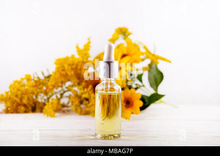 Ätherisches Öl fallen von Glas dropper ätherische Öle und medizinische Blumen Kräuter. Stockfoto