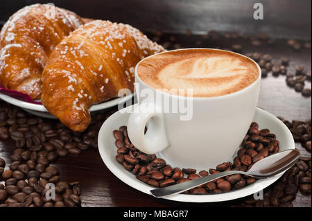 Cappuccino und Croissants und Kaffee Bohnen Stockfoto