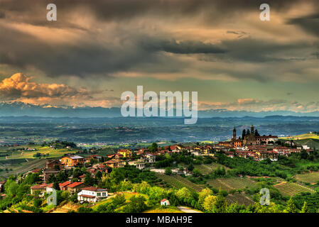 Das Dorf Rodello, in der Langhe (Piemont, Italien), von Hügeln mit Weinbergen umgeben und im Hintergrund die Alpen. Stockfoto