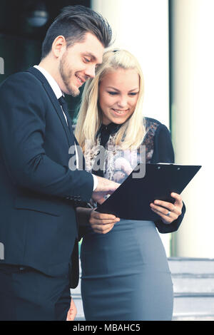 Business Paar diskutieren Dokument stehen außerhalb der Gebäude Stockfoto