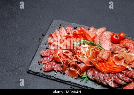 Verschiedene Arten von getrockneten Bio salami Wurst und Parma am konkreten Hintergrund Stockfoto