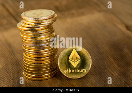 Stapel von Goldmünzen mit Logo des Astraleums in Nahaufnahme auf hölzernen Tisch mit Platz kopieren Stockfoto