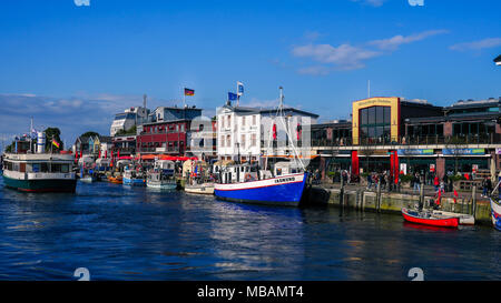 Eine lebendige Promenade in der deutschen Stadt Rostock an der Ostsee liegt. Abgebildet ist die pulsierende Warnemünde am Meer entfernt. Stockfoto