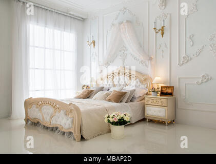 Elegante weisse klassische Schlafzimmer mit schönen Blumenstrauß Stockfoto