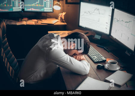 Junger bärtiger Mann Händler im Büro liegen auf dem Tisch müde Stockfoto