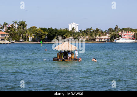 Junge Menschen in einem schwimmenden Tiki Hut, um Drinks auf Urlaub in Fort Lauderdale, Florida. Stockfoto