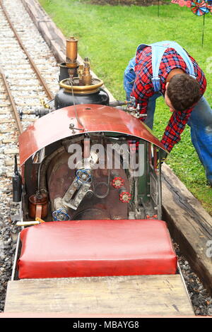 Ingenieur Vorbereitung einer Miniatur Dampflokomotive für einen Lauf Stockfoto