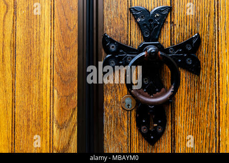 Alten schwarzen antiken Türklopfer auf hölzernen Tür Stockfoto