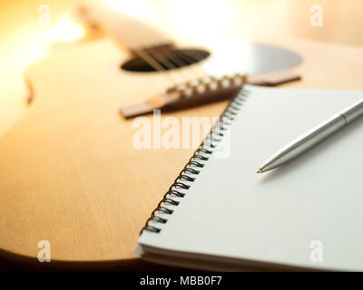 Musik Instrumente, Gitarre, Notizbuch und Stift auf Holz- Hintergrund Stockfoto