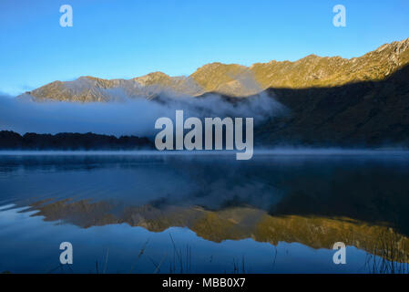 Morgennebel auf Moke Lake in der Nähe von Queenstown, Neuseeland Stockfoto