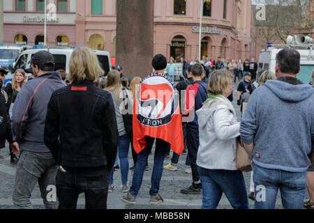 Mainz, Deutschland. 9. April 2018. Eine Demonstrantin trägt eine antifaschistische Aktion Flagge über die Schulter. Rund 50 Rechtsextreme Demonstranten sammelten sich in der Innenstadt von Mainz, gegen die deutsche Regierung zu protestieren, für die Schließung der Grenzen und gegen Flüchtlinge unter dem Motto 'MErkel hat zu gehen'. Sie wurden von rund 400 Zähler Gehechelt-Demonstranten. Quelle: Michael Debets/Alamy leben Nachrichten Stockfoto