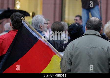 Mainz, Deutschland. 9. April 2018. Ein rechter Demonstrant trägt eine deutsche Flagge. Rund 50 Rechtsextreme Demonstranten in der Innenstadt von Mainz sammelte, gegen die deutsche Regierung zu protestieren, für die Schließung der Grenzen und gegen Flüchtlinge unter dem Motto goÕ ÔMerkel hat. Sie wurden von rund 400 Zähler Gehechelt-Demonstranten. Quelle: Michael Debets/Alamy leben Nachrichten Stockfoto