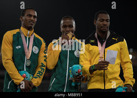 Queensland, Australien. 10 Apr, 2018. Goldmedaillenträger Südafrikas Akani Simbine wirft mit silbermedaillengewinner Südafrikas Henricho Bruintjies (L) und Bronze Der medaillenträger Jamaika Yohan Blake (R) Während der Leichtathletik Männer 100 m-finale Siegerehrung Während der Commonwealth Games 2018 Gold Coast an der Carrara Stadion an der Gold Coast am 10. April 2018. Credit: Ben Stand/Alamy leben Nachrichten Stockfoto