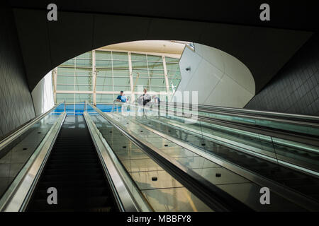 Reisende am Flughafen Denver International Airport auf der Rolltreppe zum Bahnhof. Stockfoto