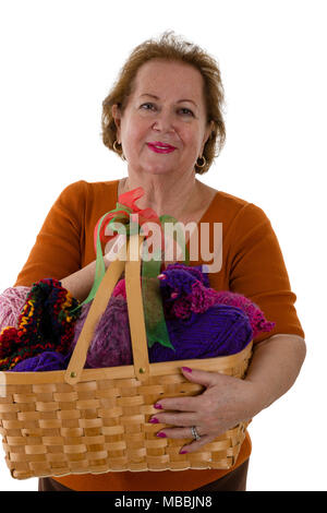 Portrait von fröhlichen älteren Frau mit Korb mit bunten Garnen Stockfoto