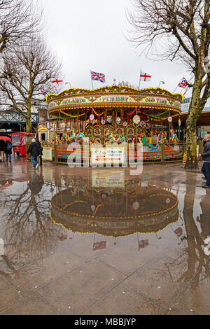 Ein Jahrmarkt am Südufer der Themse in London, in einem Pool von Regen Wasser wider. Stockfoto