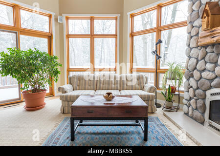 Upscale Wohnzimmer. Einladende Szene mit vielen Fenstern und einer modernen Einrichtung. Stockfoto