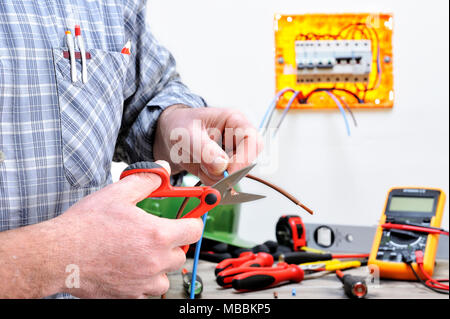 Elektriker Techniker bei der Arbeit in einem Wohngebiet elektrische Installation, schneidet das Kabel Stockfoto